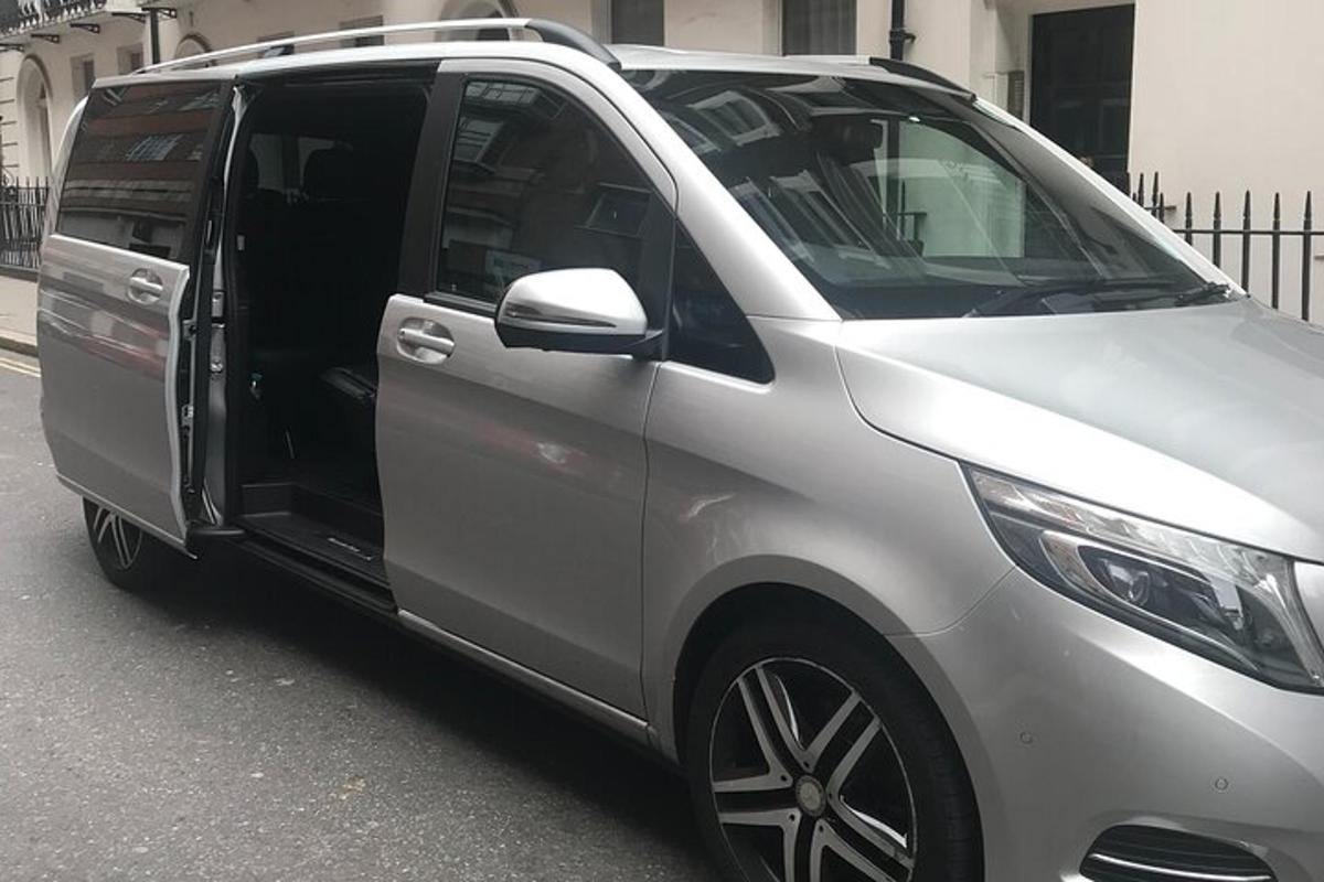 hopeinen pakettiauto, jonka ovi on auki kadulla