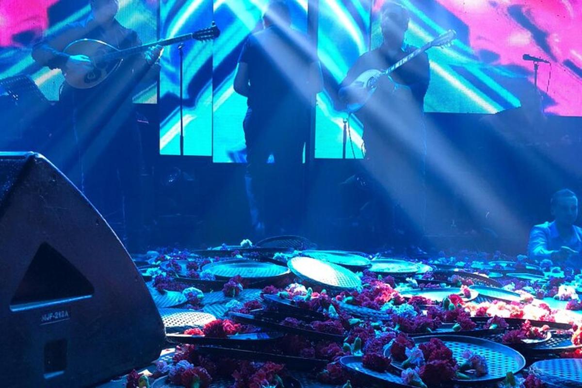 um palco com um monte de bateria e pessoas ao fundo