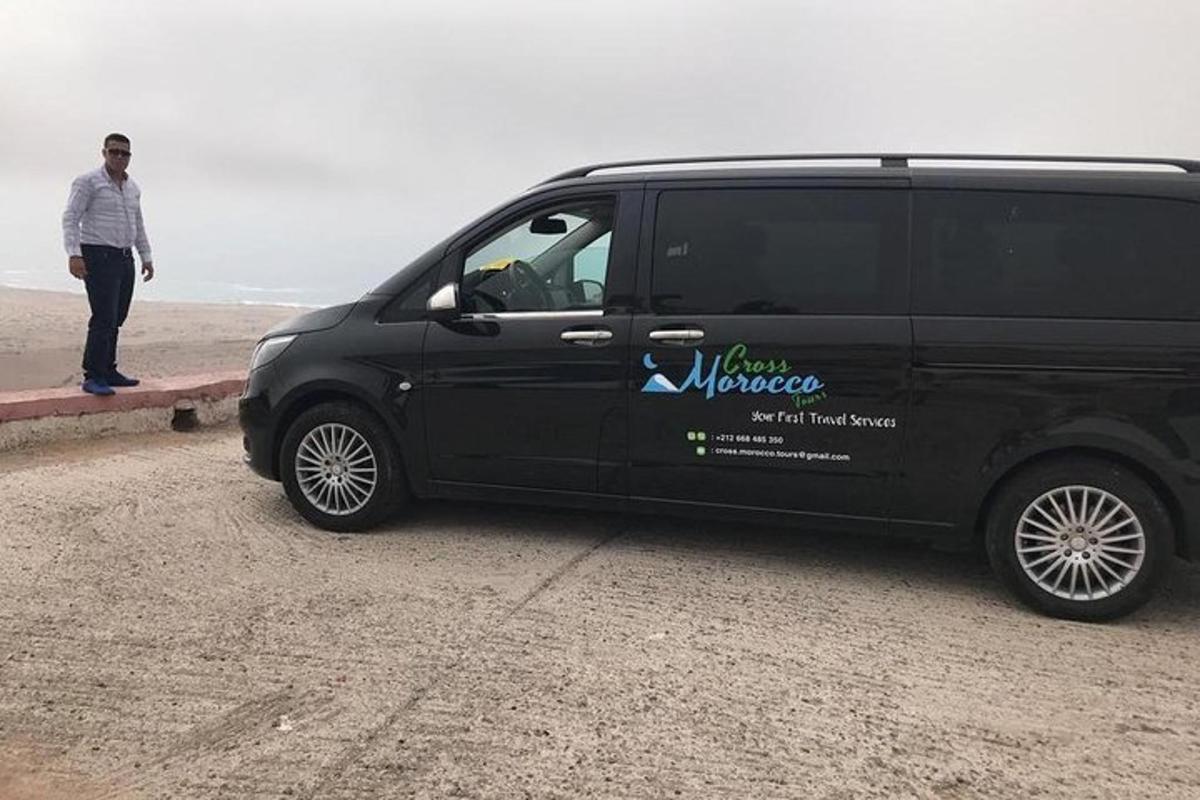 a man is standing next to a black van
