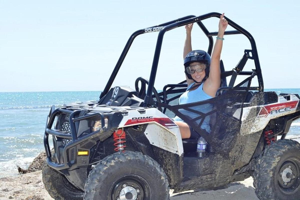 seorang wanita duduk di atv di pantai