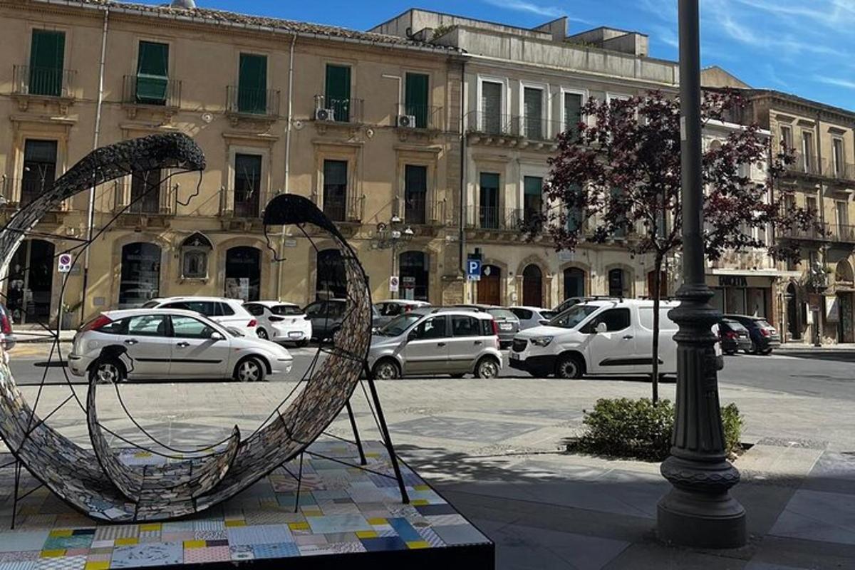 uma escultura de metal de um barco em uma rua da cidade