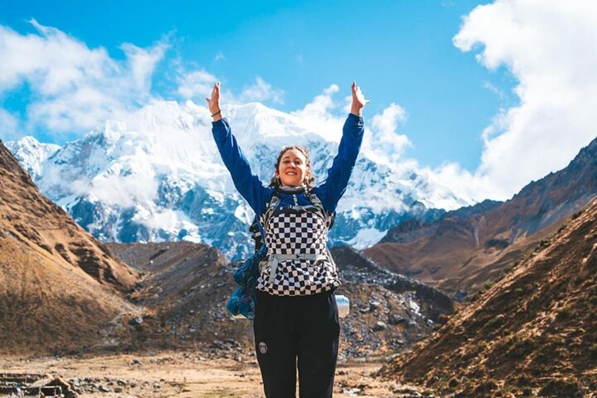 una donna in piedi su una montagna con le mani in aria