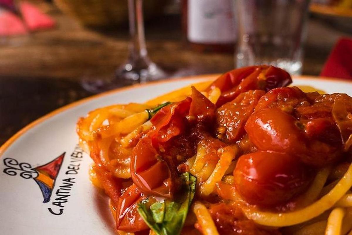 Diskur af mat með pasta og tómötum á borði