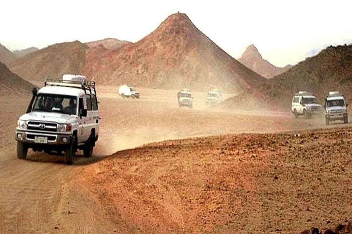 un gruppo di auto che percorrono una strada sterrata