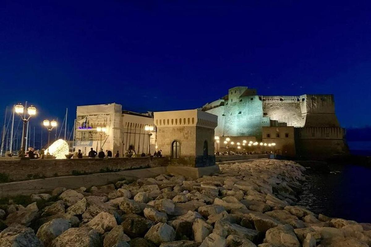 un grande edificio di notte con rocce di fronte