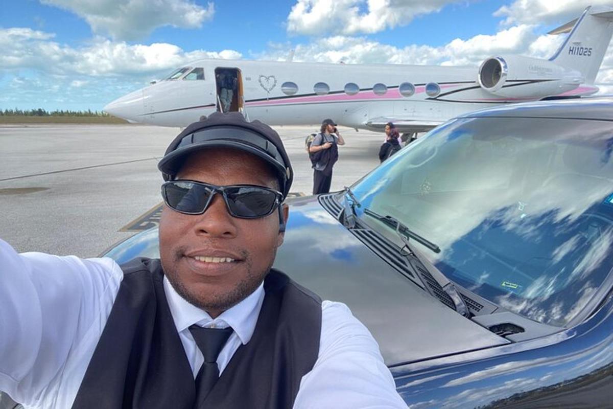 a man wearing a hat and sunglasses next to an airplane