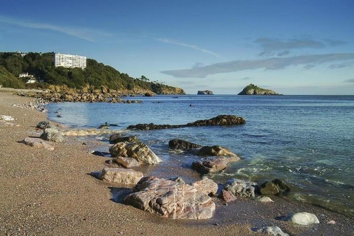 una spiaggia con rocce nell'acqua e un'isola