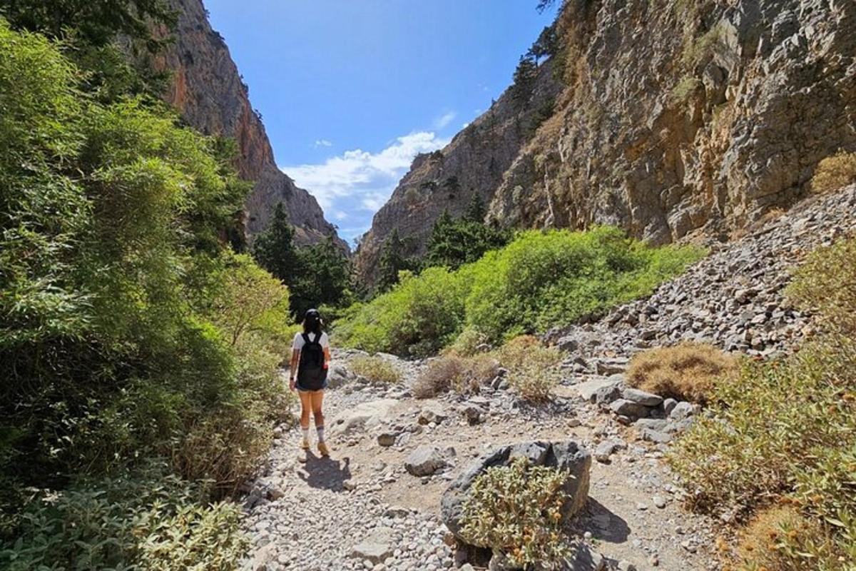 una donna che cammina su un sentiero roccioso in un canyon