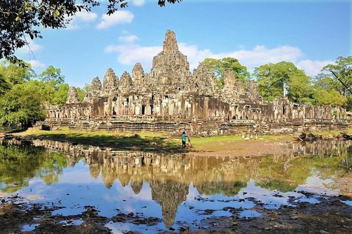 một người đứng trước một tòa nhà cổ kính với hình ảnh phản chiếu của nó trong nước