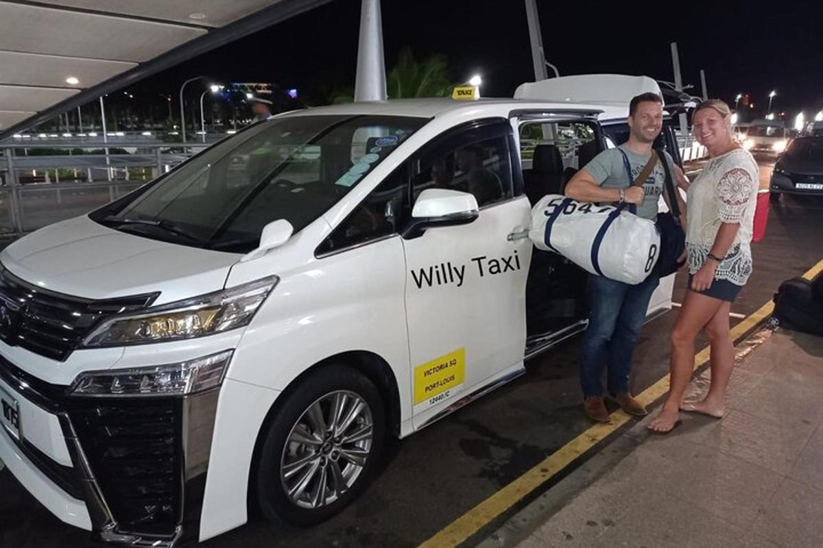 dva lidé stojící vedle bílého kyvadlového taxi