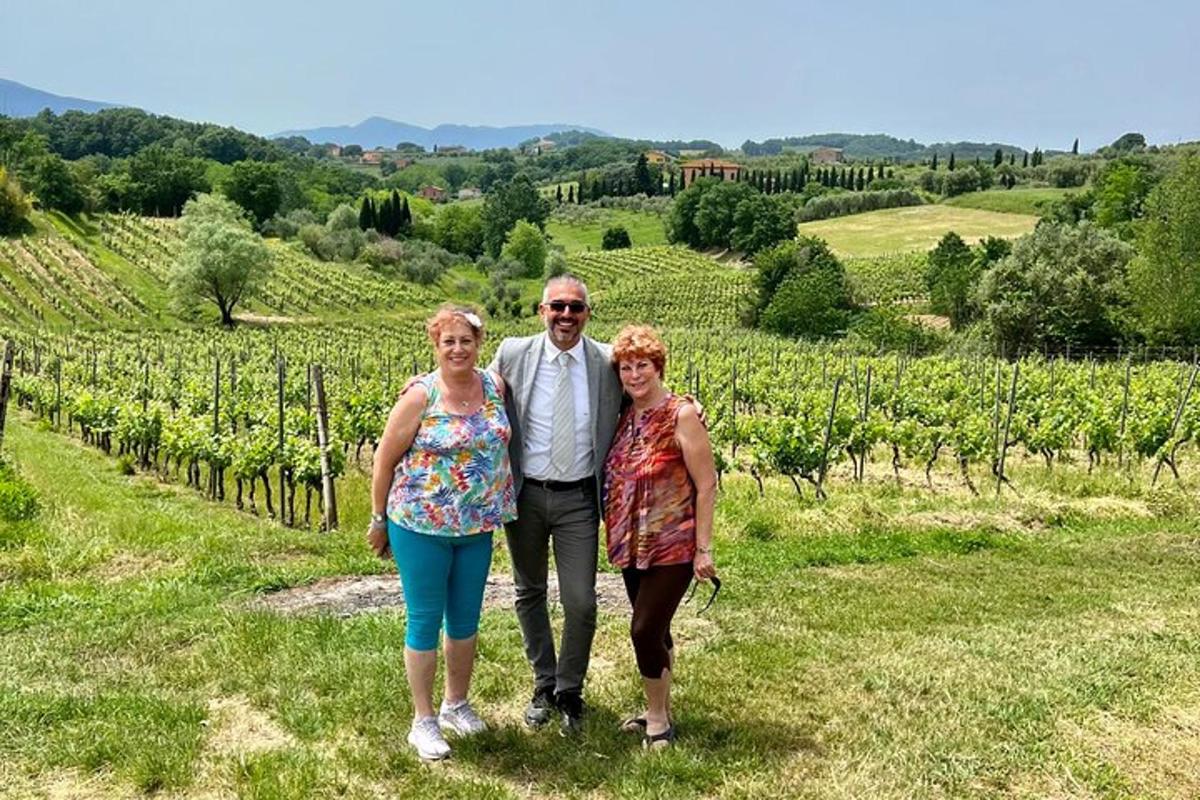 moški in dve ženski stojita pred vinogradom
