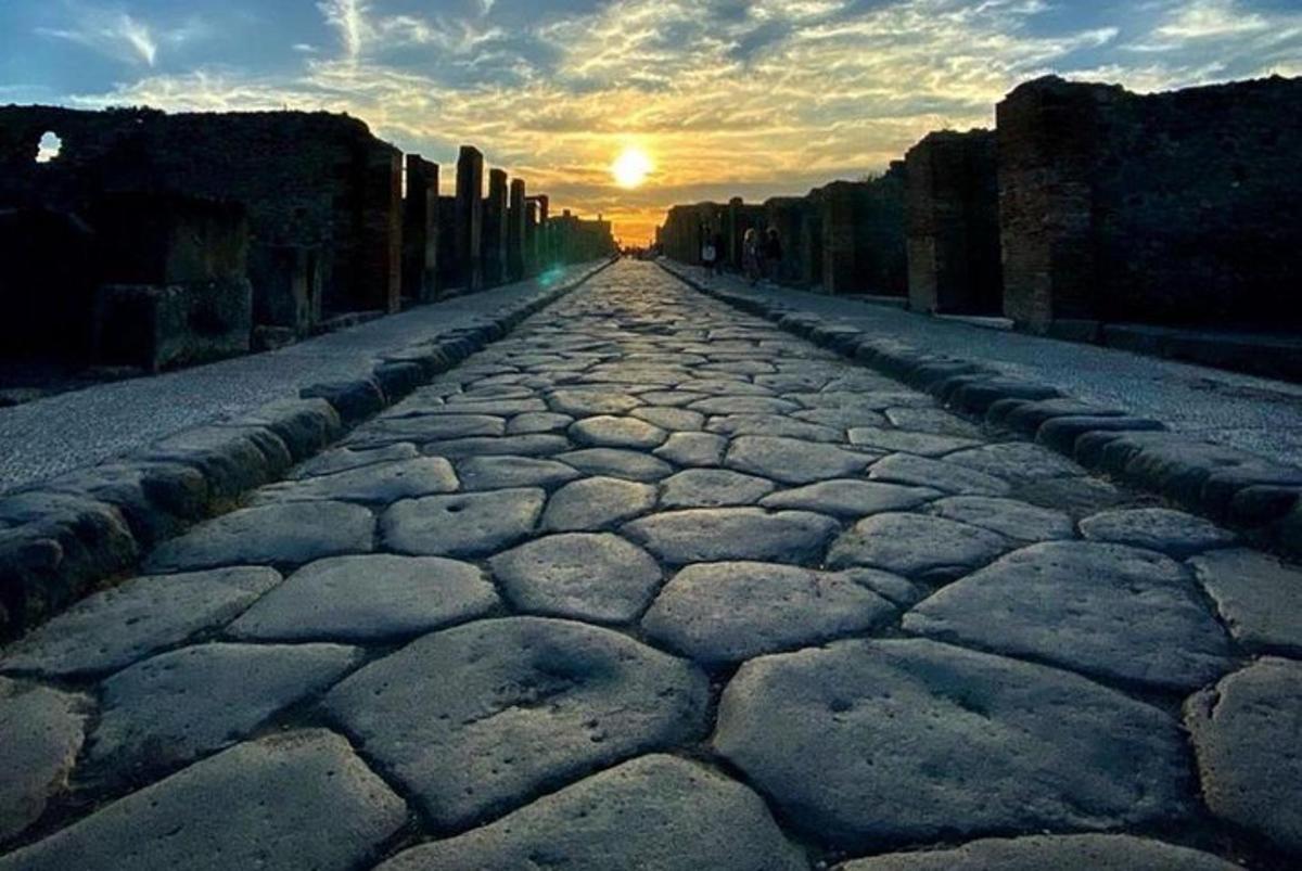 uma estrada de pedra com o pôr do sol ao fundo