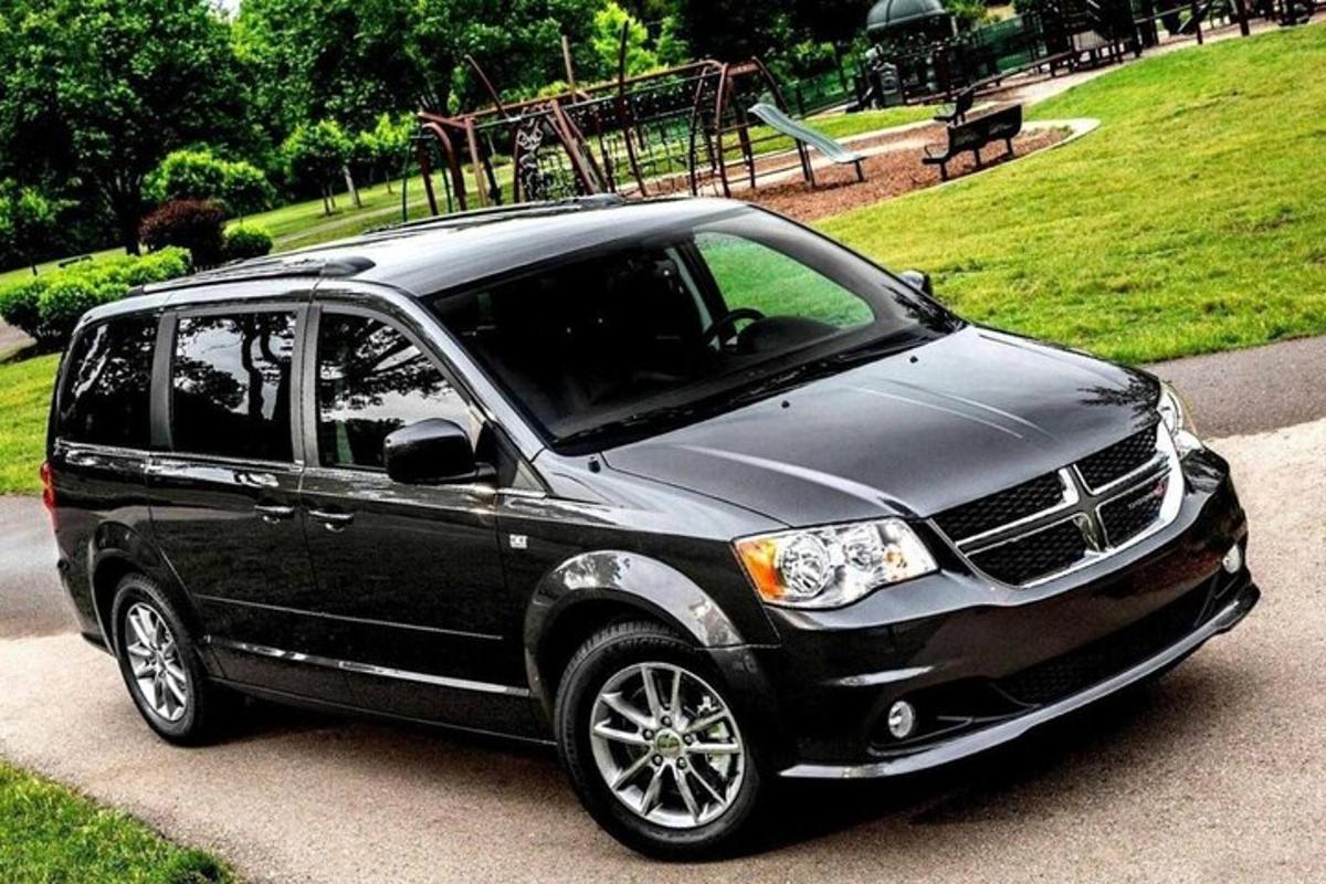 a black suv parked in a park with a playground
