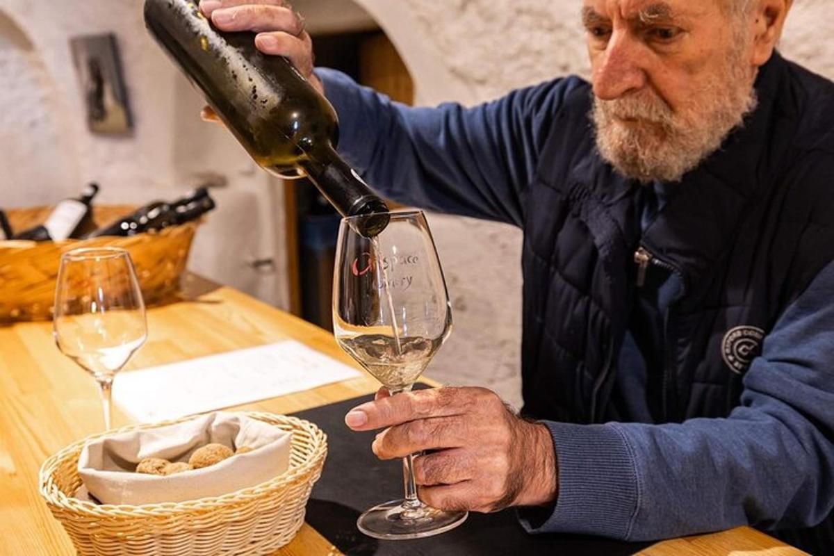 um homem despejando vinho em uma taça de vinho