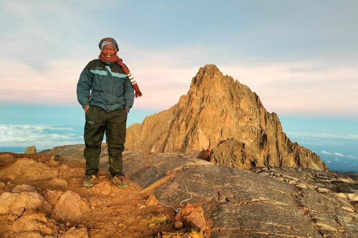 un hombre parado en la cima de una montaña