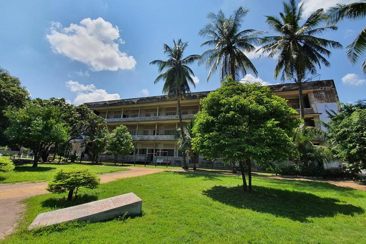 um edifício com palmeiras e um banco em um parque