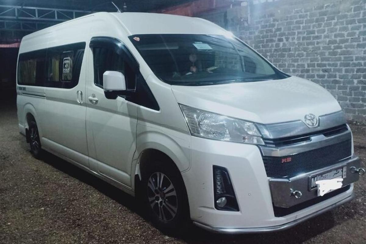 レンガの壁の隣に駐車された白いバン