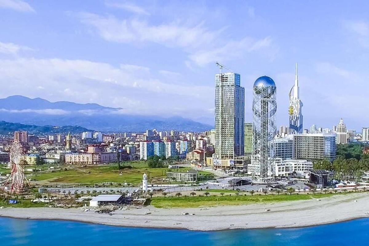 a view of a city with tall buildings and the ocean