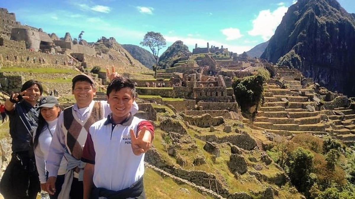 Un grupo de personas de pie frente a unas ruinas.