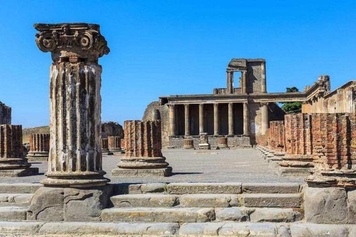 μια ομάδα αρχαίων ερειπίων με μια στήλη μπροστά από ένα κτίριο