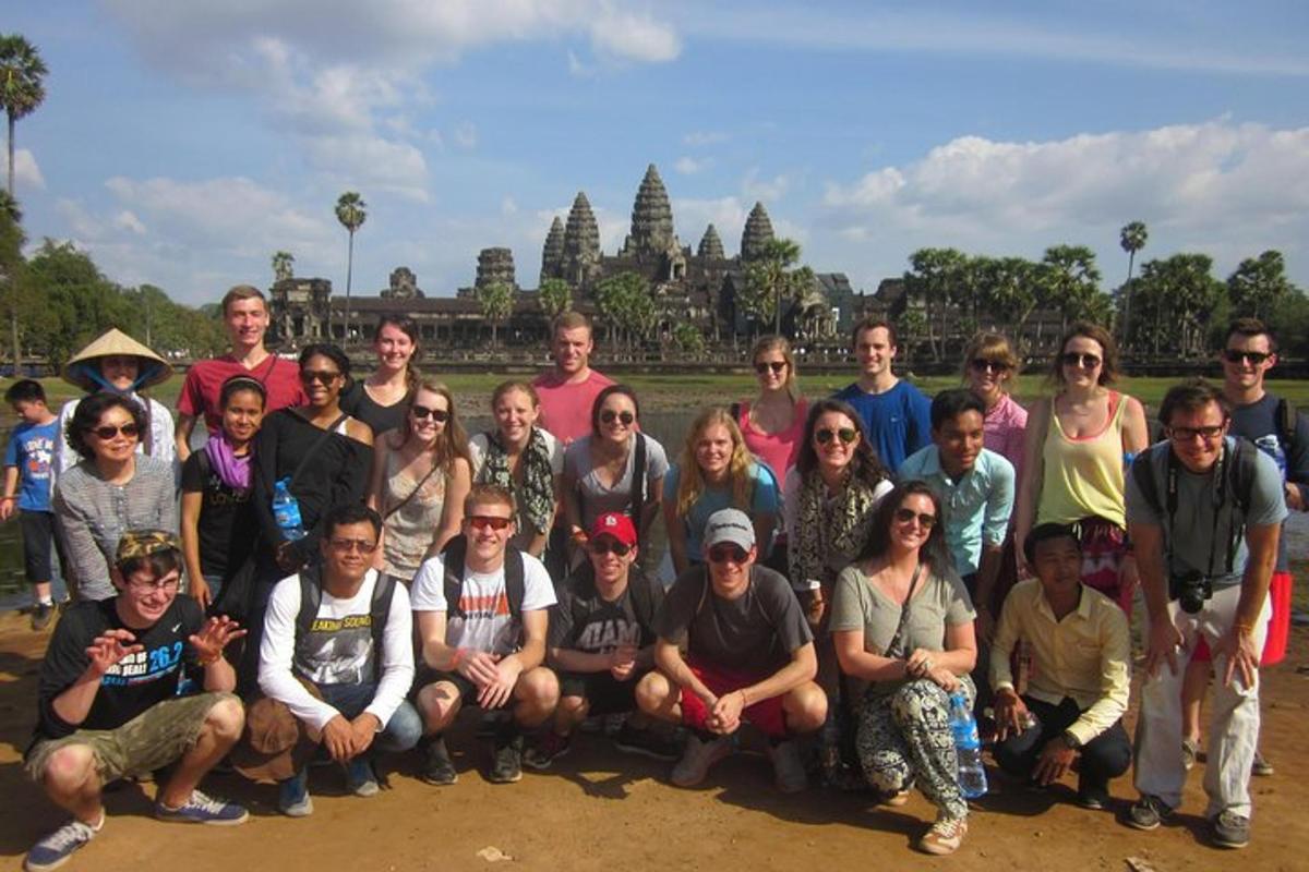 a group of people posing for a picture in front of a temple