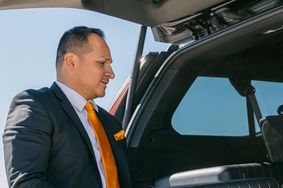 ein Mann in Anzug und orangefarbener Krawatte in einem Auto