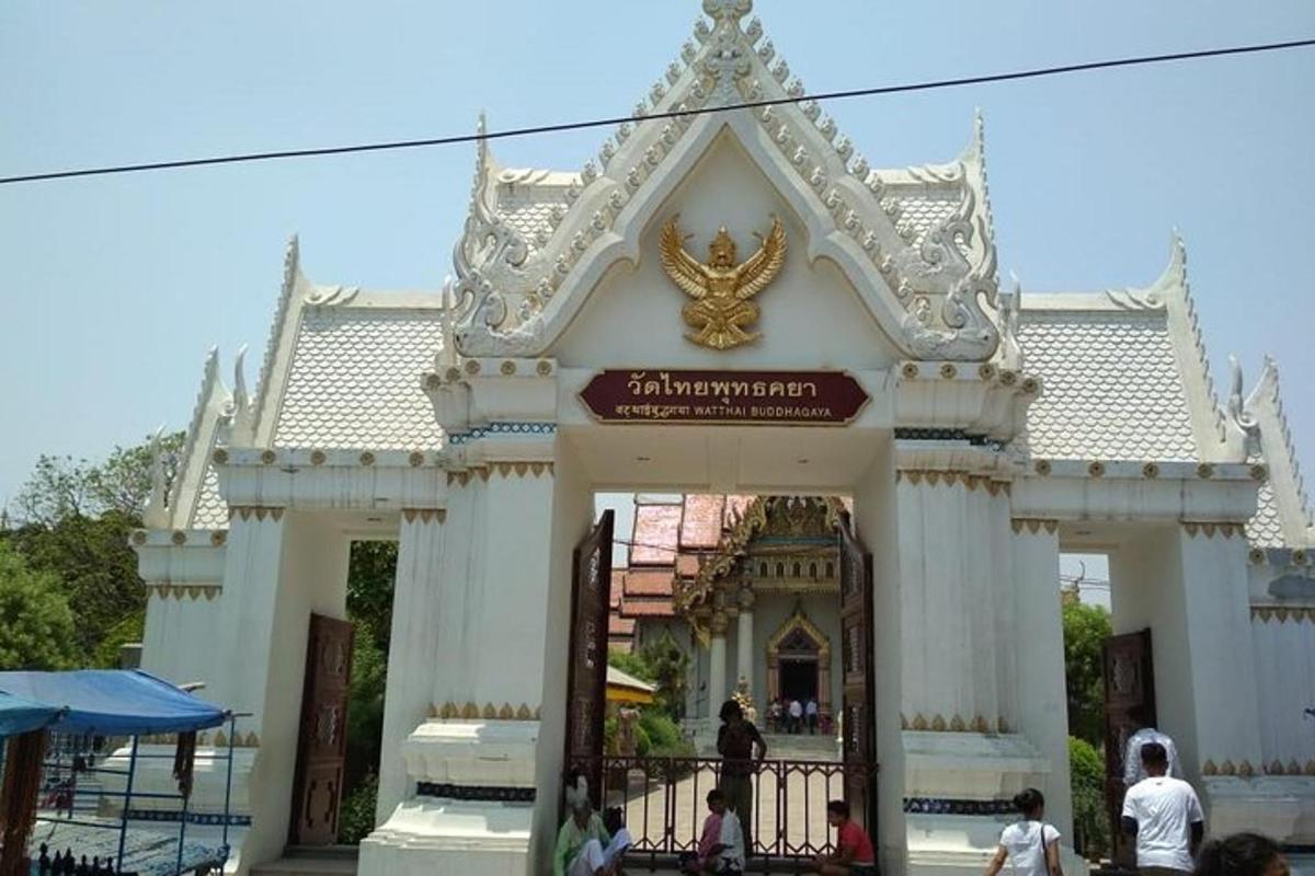 a white temple with a gate in front of it