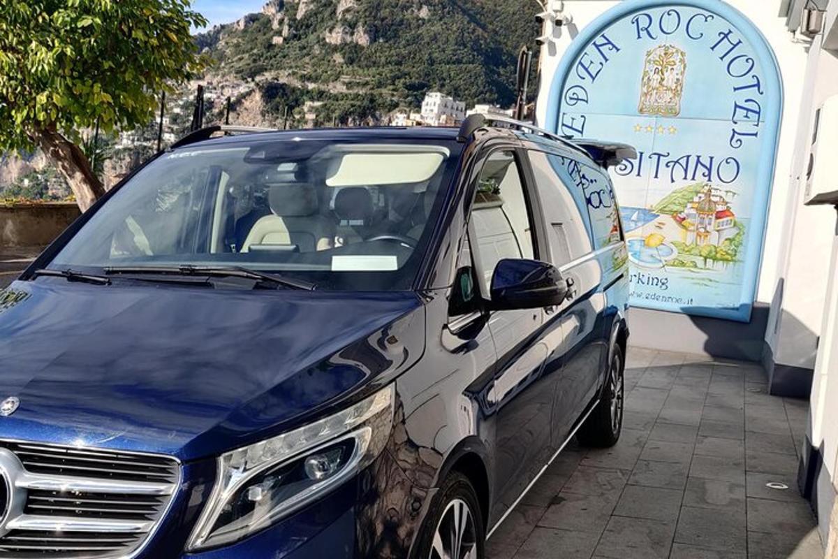 Un coche azul y blanco aparcado junto a un edificio.