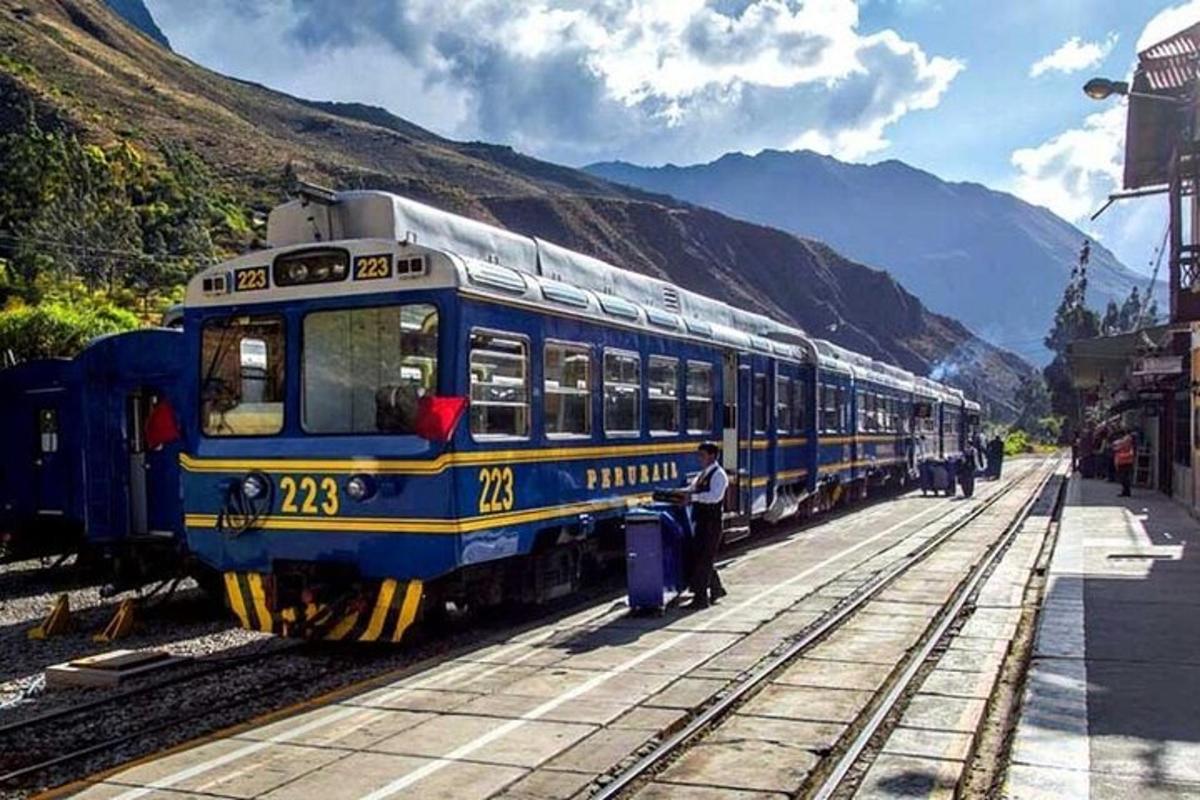 isang asul at dilaw na tren ang nasa riles