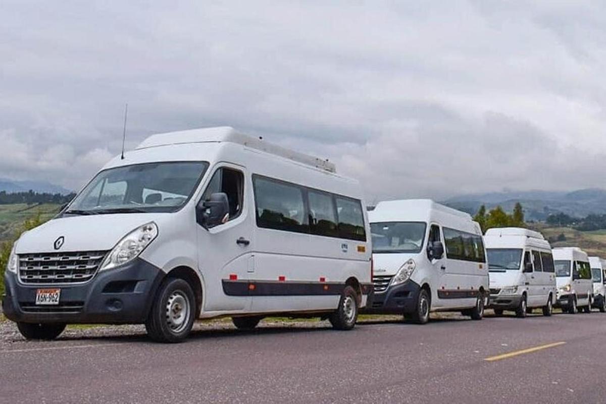 a line of white vans parked in a parking lot