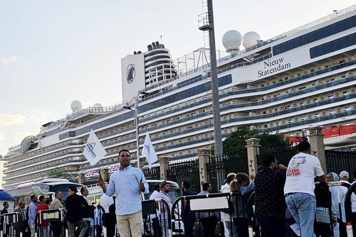 una folla di persone in piedi davanti a una nave da crociera