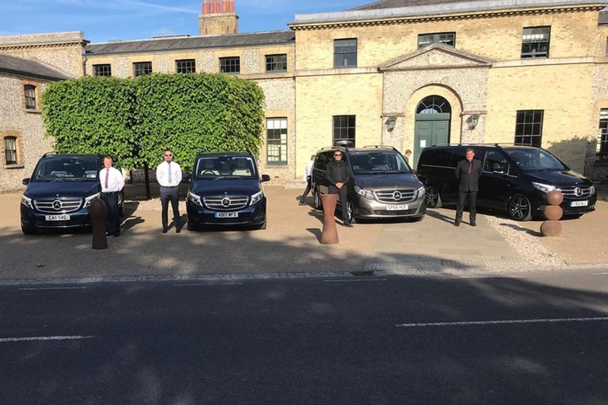 un grup de persones dempeus davant de cotxes aparcats