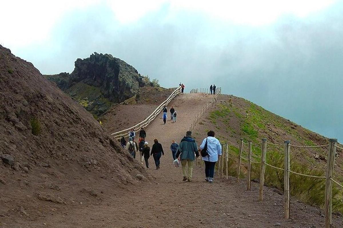 un grupo de personas caminando por un sendero en una colina