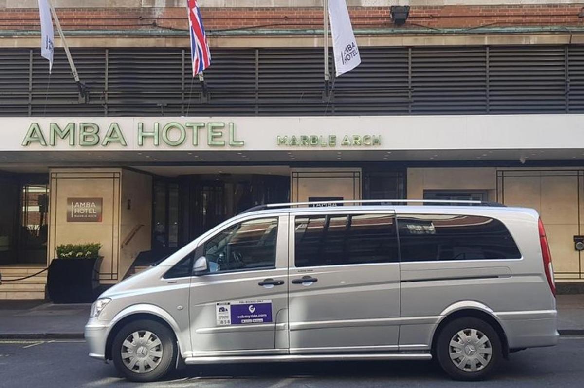 a silver van parked in front of a hotel
