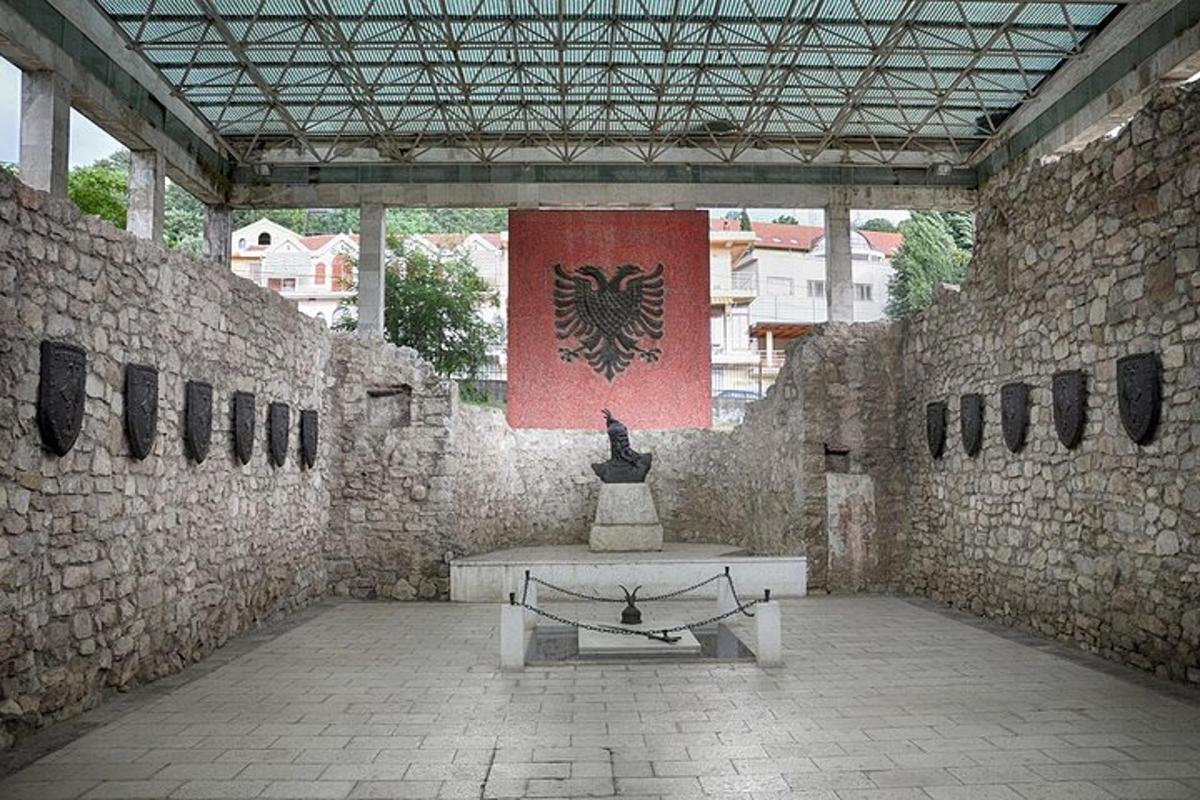 un edificio in pietra con una panchina e una bandiera