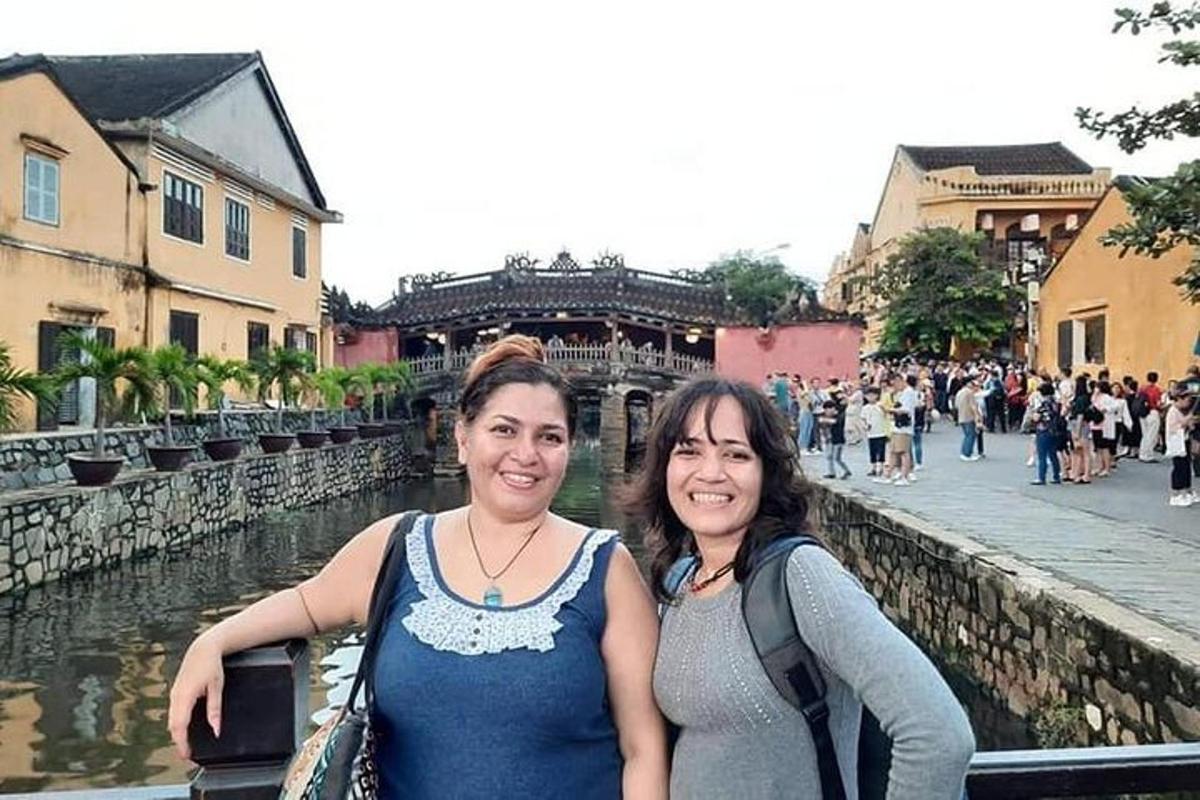 dues dones dempeus al costat d'un riu en una ciutat