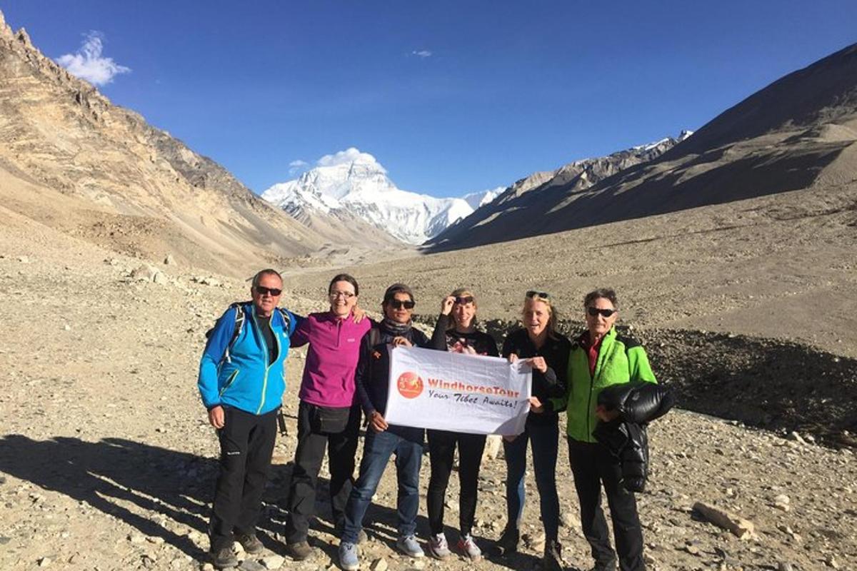 a group of people holding a sign on a mountain
