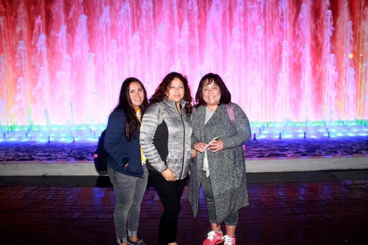 three women are standing in front of a fountain