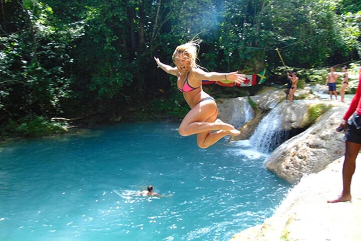 una donna in bikini che salta in un fiume