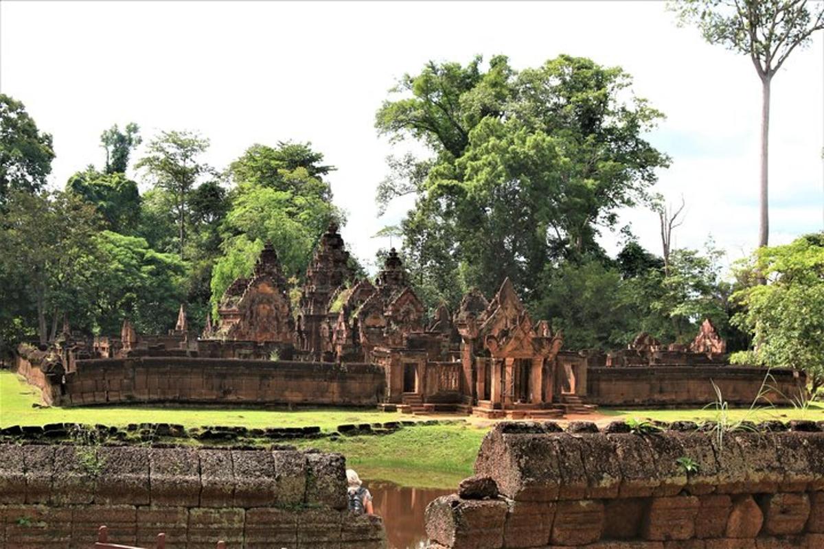 an ancient building in a field with trees in the background