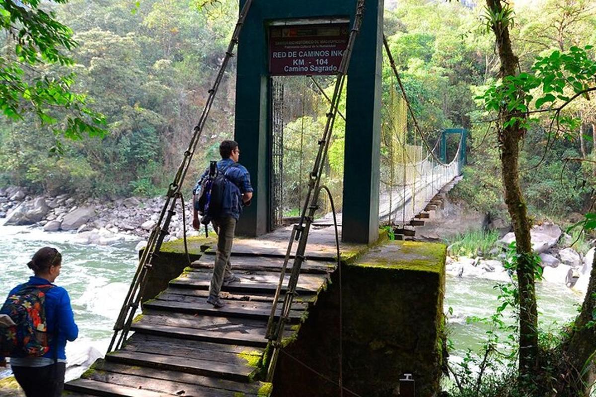 un home caminant per un pont penjant sobre un riu