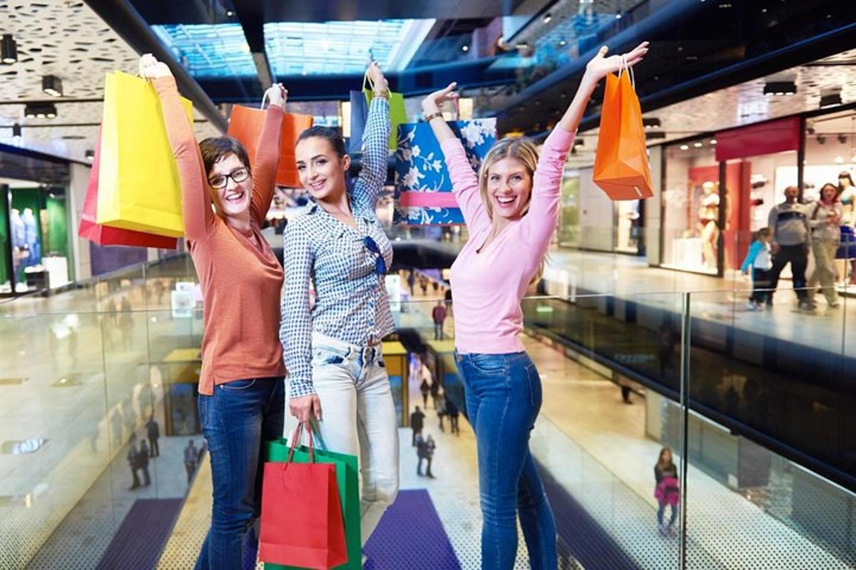 tre donne che tengono borse della spesa in un centro commerciale