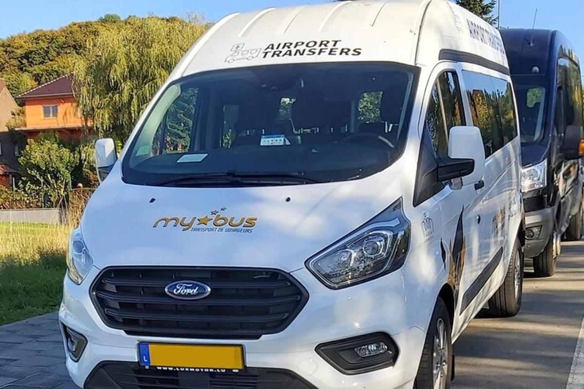 sebuah van putih diparkir di sebelah bus