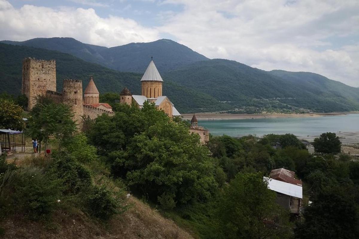 a castle on a hill next to a body of water