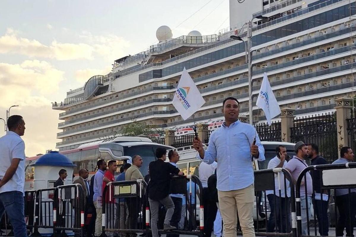 Un grupo de personas de pie frente a un crucero.