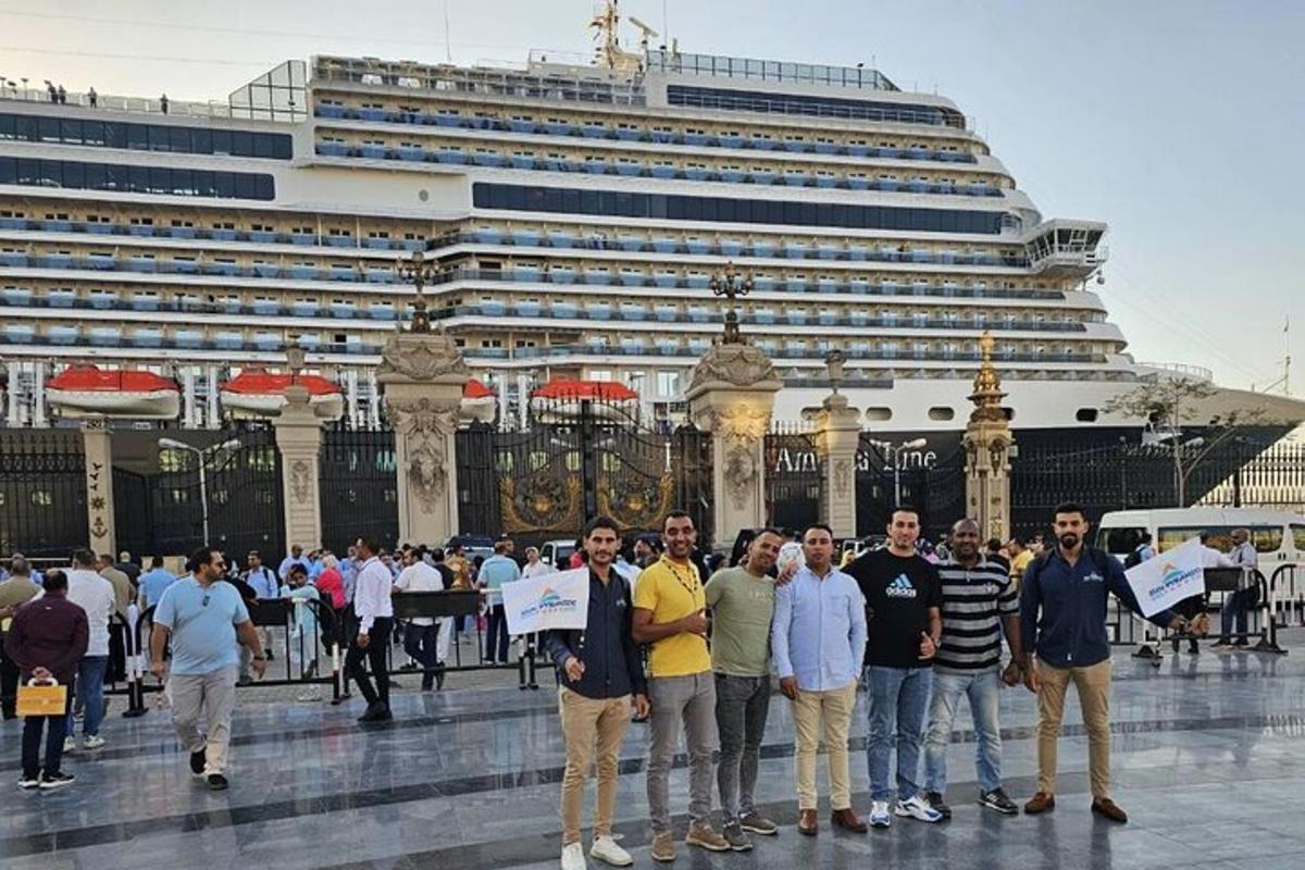 Un grupo de personas de pie frente a un crucero.