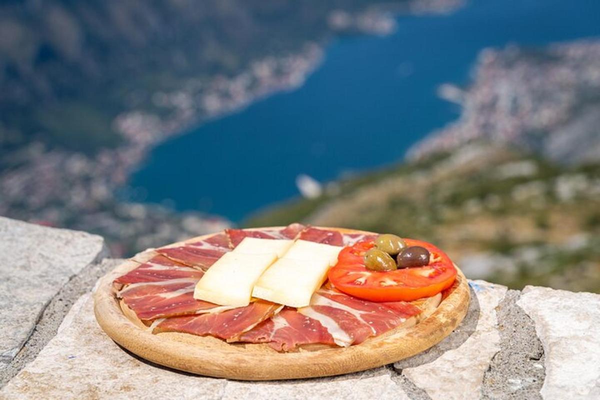 un piatto di cibo con carne, formaggio e pomodori