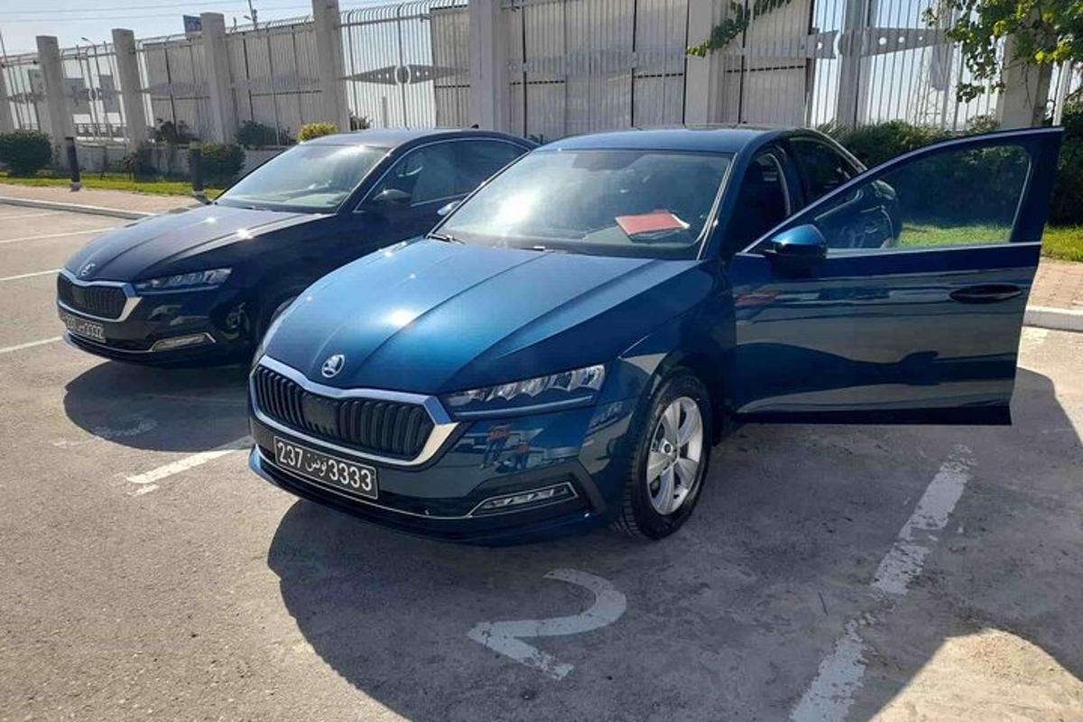 two blue cars parked in a parking lot
