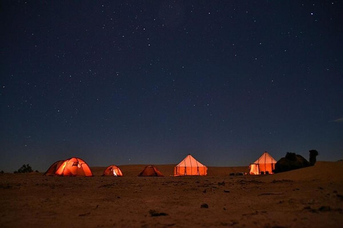 a group of tents in the desert at night
