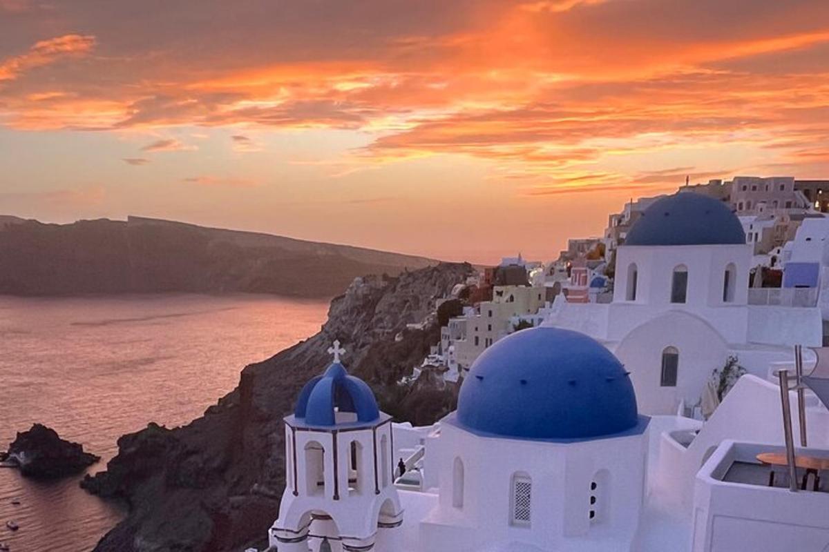 Západ slunce nad skupinou bílých budov a oceánem